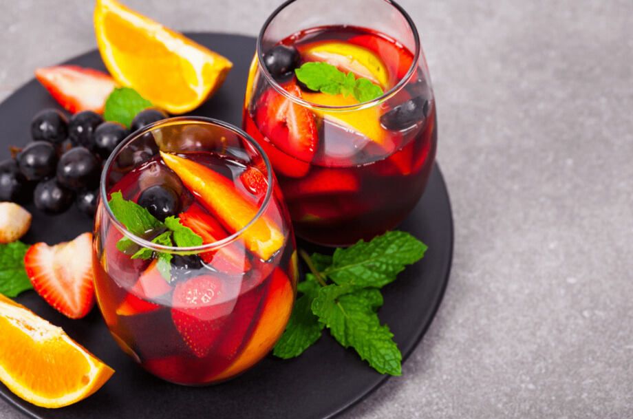Red Wine Sangria with lemon, lime, apple, grapes, strawberries and orange served in a glass.