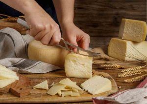 cutting hard cheese on a cheese board
