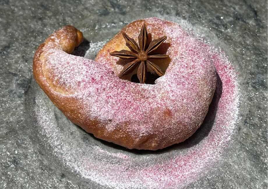 An exquisitely Ensaimada Mallorquina, decorated with star anise, adding a touch of elegance and a hint of spice to the classic pastry.