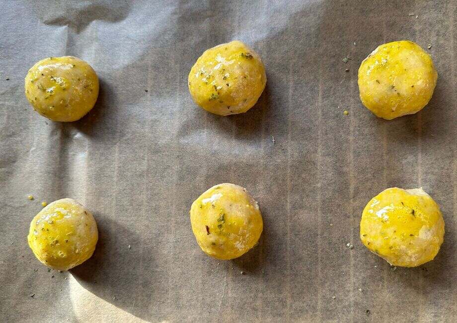 Sprinkle oregano on dough balls for extra flavor.