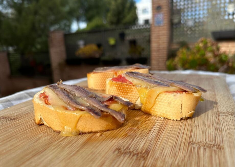 Toasted bread, juicy tomato, melted Mahón, and briny anchovies—delicious!