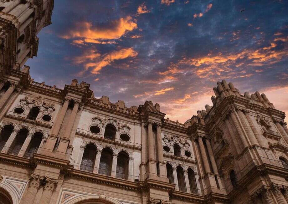Exterior view of Málaga Cathedral with its single bell tower and Renaissance-Baroque architecture.