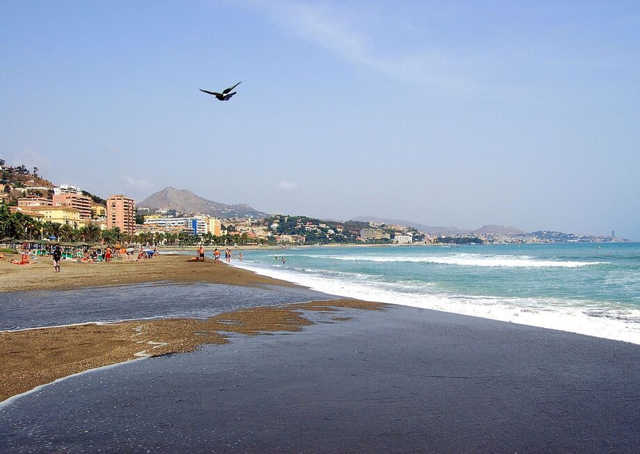 It is a popular urban beach, known for its dark sand, calm waters and proximity to the historic centre.