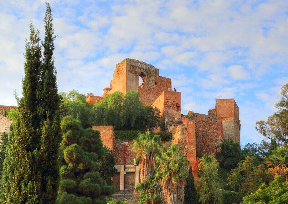 The Moorish Alcazaba fortress with stone walls, gardens, and views overlooking Málaga and the sea.
