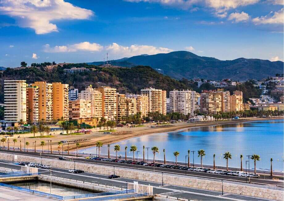 Málaga city with the Mediterranean Sea, historic architecture, and palm-lined streets.