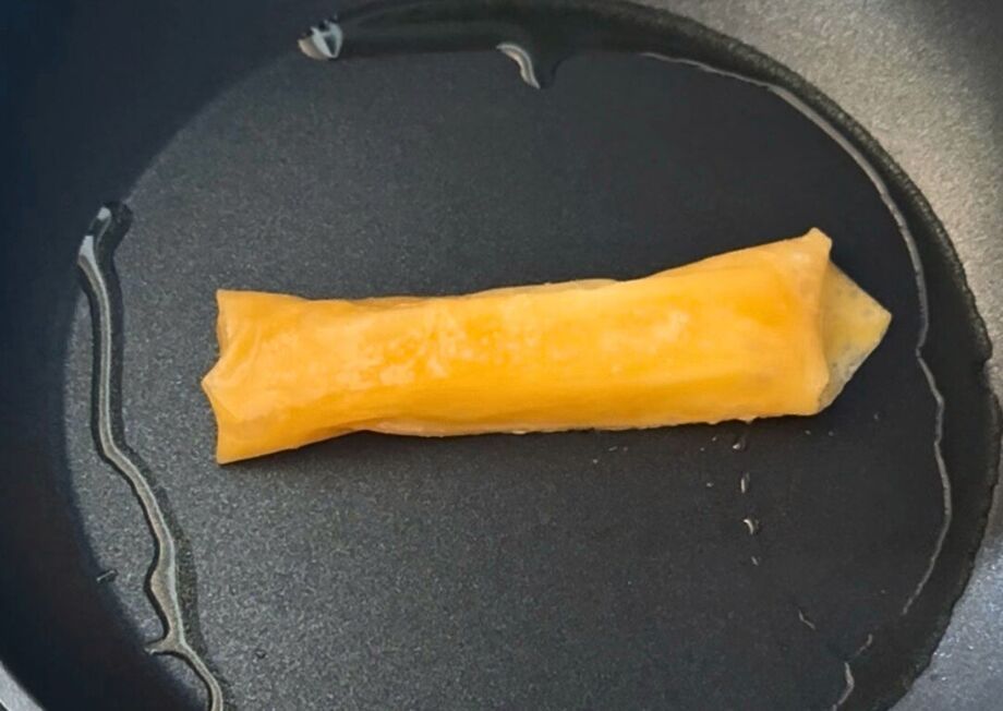 Non-fried cheese sticks cooking in a pan